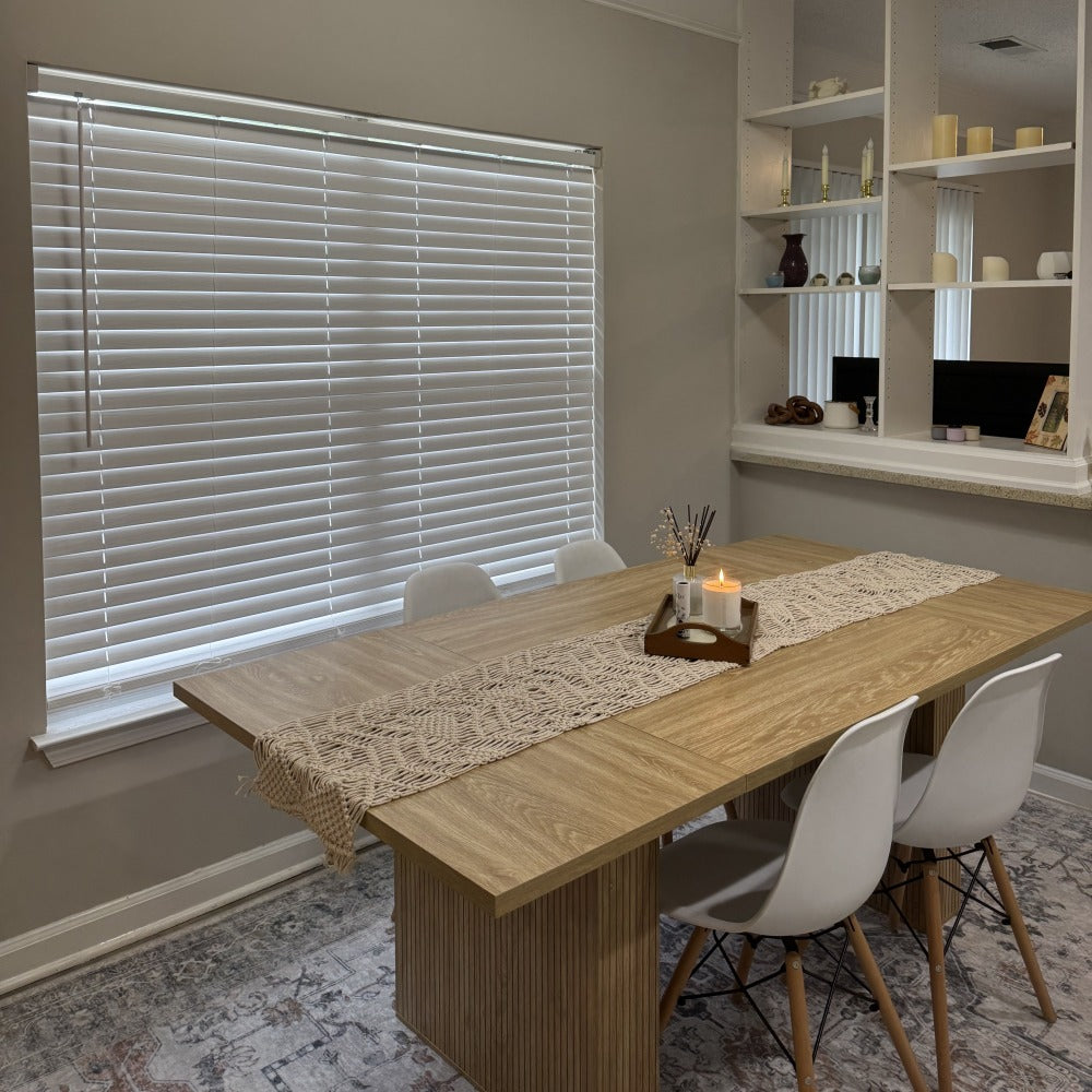 Dining room with wooden table and chairs, window with blinds, and shelves.