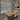 Dining room with wooden table and chairs, window with blinds, and shelves.