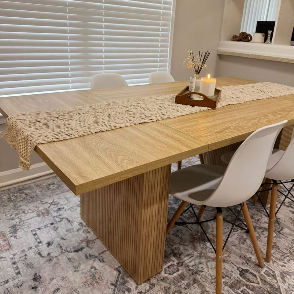 Dining table set with chairs and a decorative runner in a room with blinds.