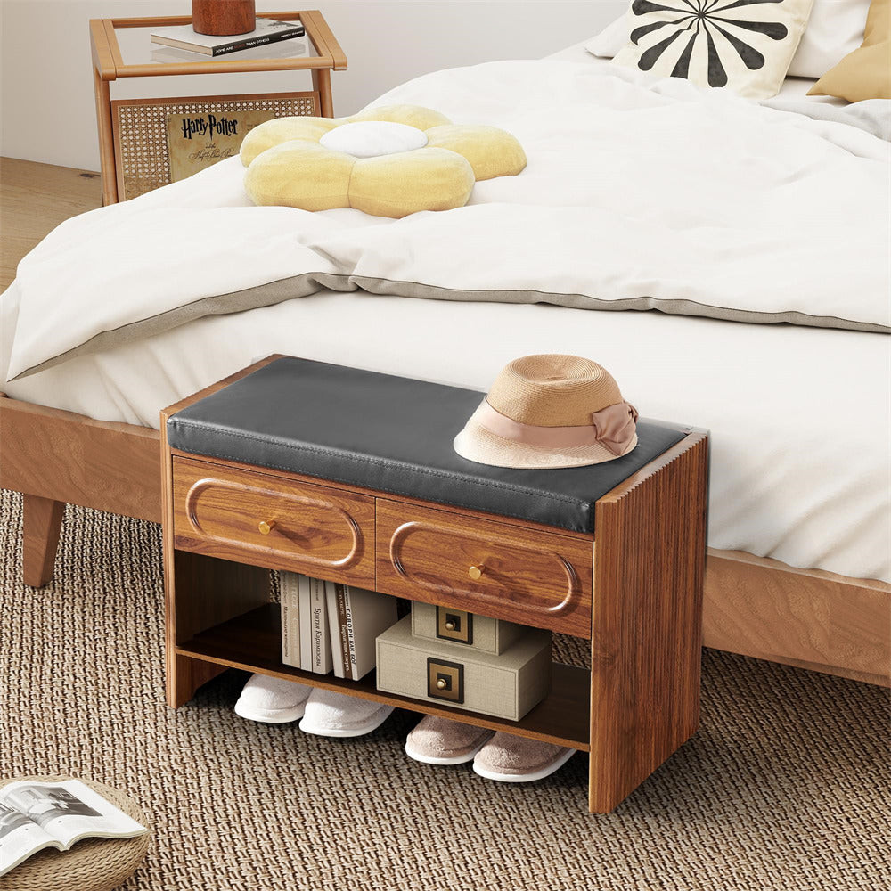 Wooden nightstand with black cushion next to a bed with white bedding and yellow pillows.