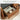 Wooden storage bench with open drawer containing tissues, bottles, and other items.