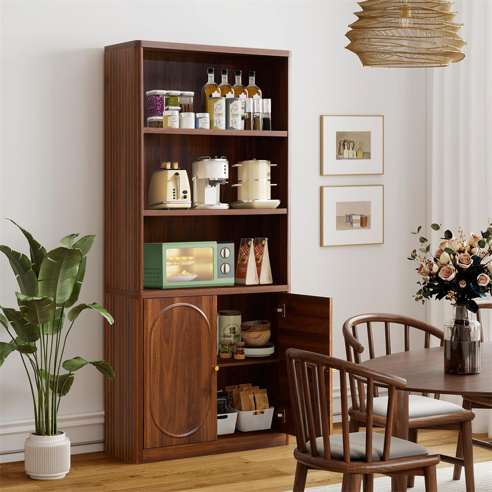 Wooden bookshelf with kitchen appliances in a room with chairs and a plant.