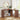 Wooden corner desk with chair, books, and decorative items in a bright room.