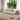 Beige sofa in a living room with large windows and wooden side tables.