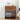 Wooden nightstand with decorative items including a lamp, clock, and books against a white wall.