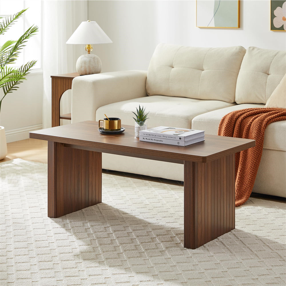Wooden coffee table in a living room with a beige sofa and decorative items.