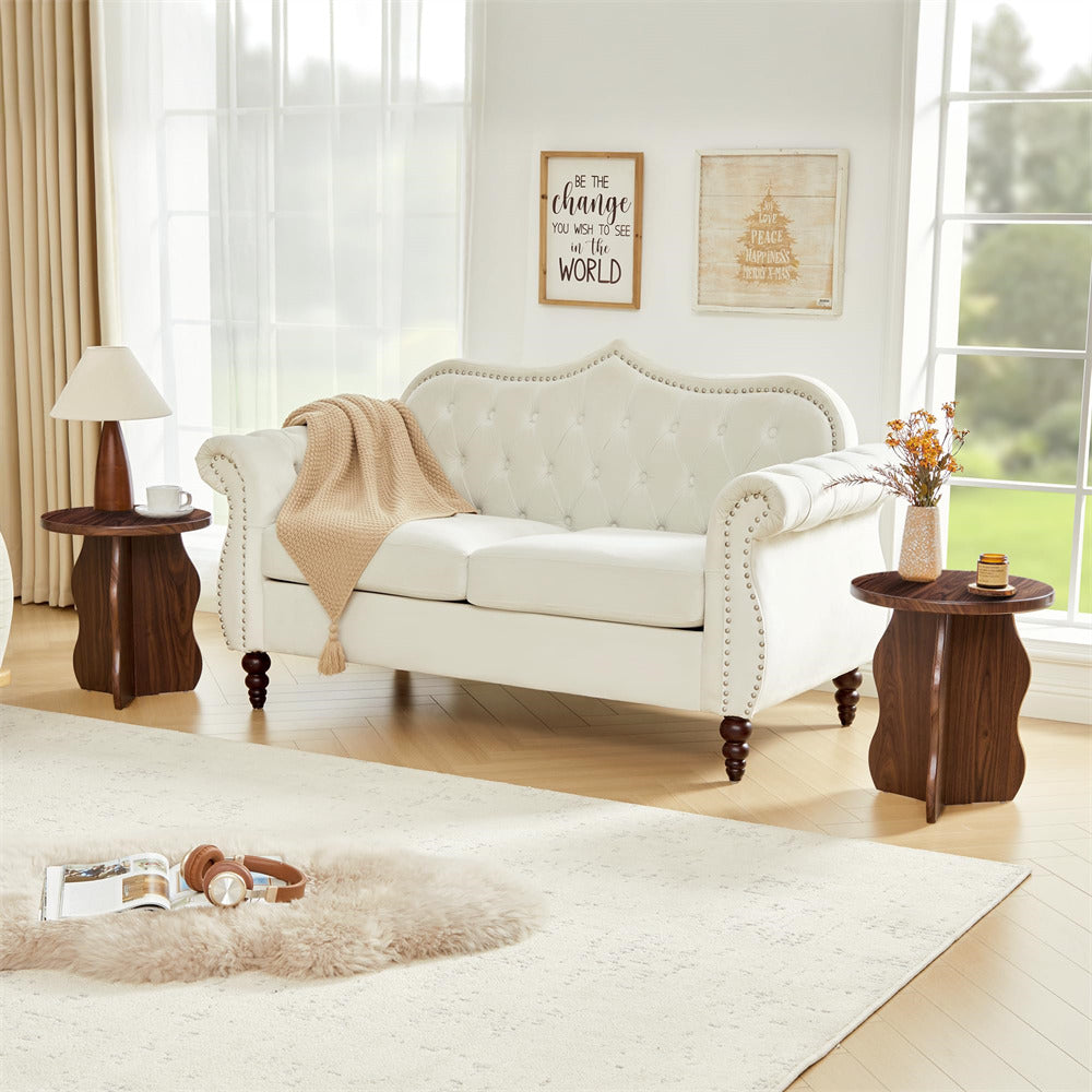 Living room with a white sofa, wooden side tables, and decorative elements.