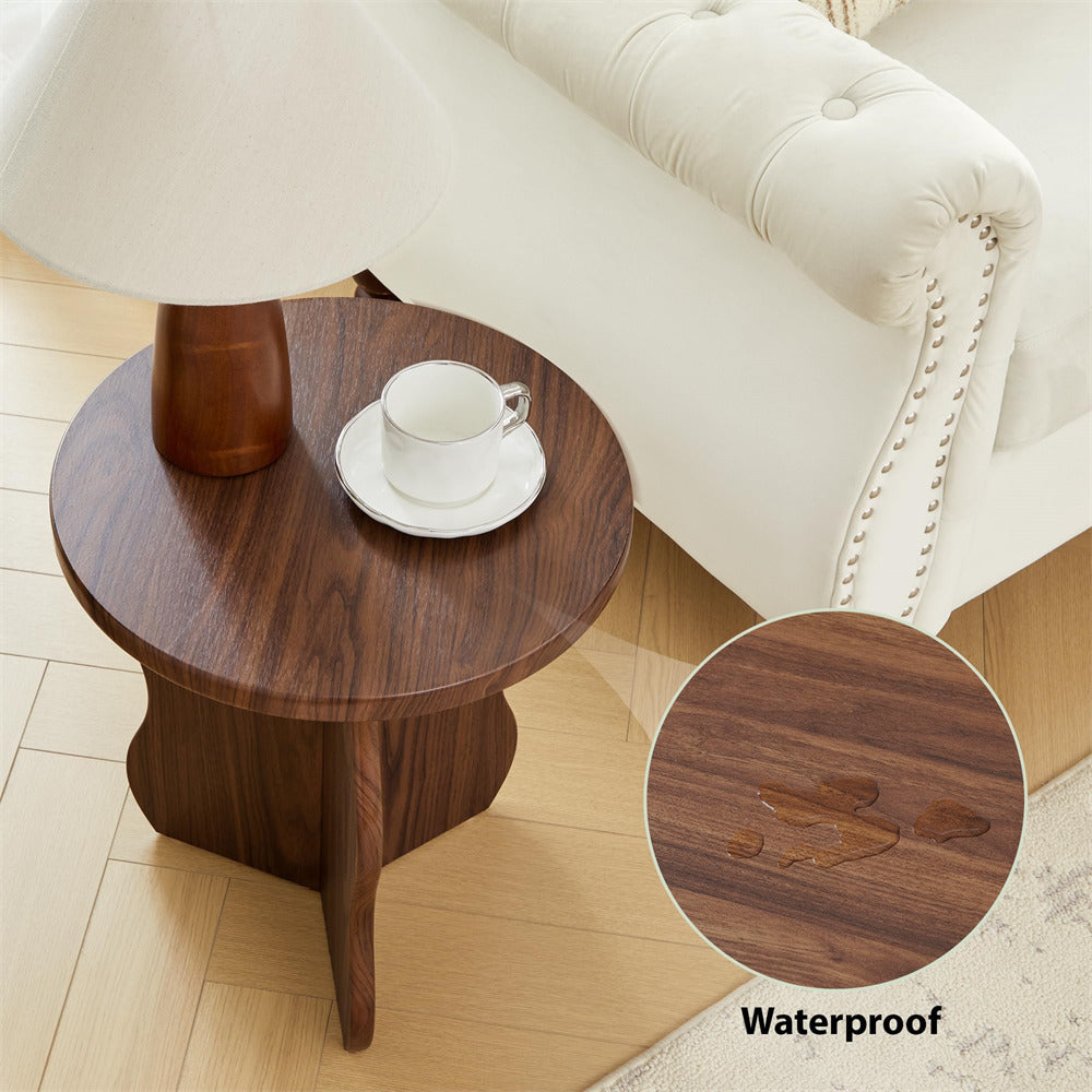 Wooden side table with a lamp and cup on a light wood floor.