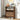 Wooden shoe cabinet with shoes inside, placed against a neutral wall with decor items.