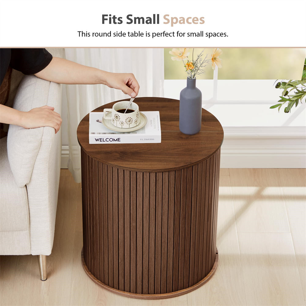 Round wooden side table in a living room setting with a cup of coffee and a vase.