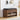 Wooden shoe storage bench with black cushion, shoes, and bags on a light wooden floor.