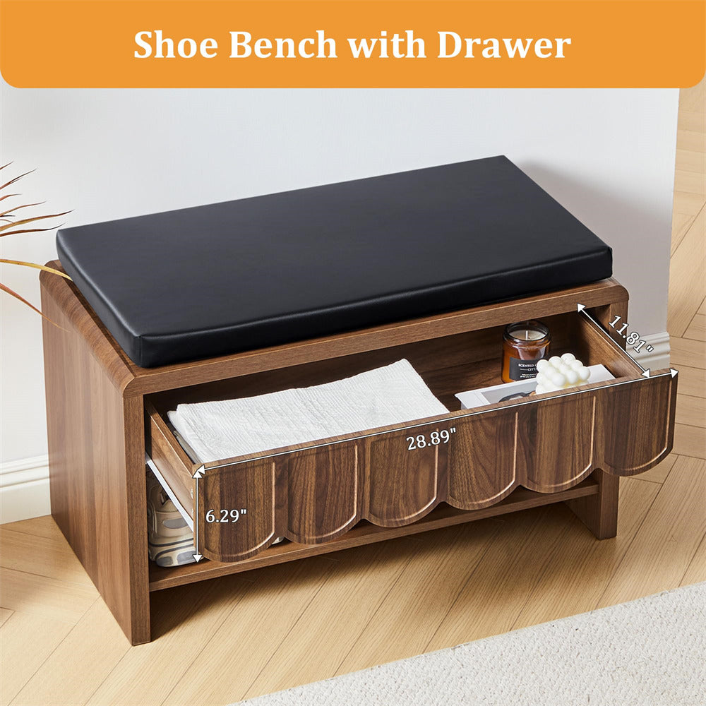 Wooden shoe bench with black cushion and open drawer on a light wood floor.
