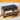 Wooden shoe bench with black cushion and open drawer on a light wood floor.