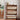 Wooden shoe rack with fabric-covered compartments in a room with a window and plant.