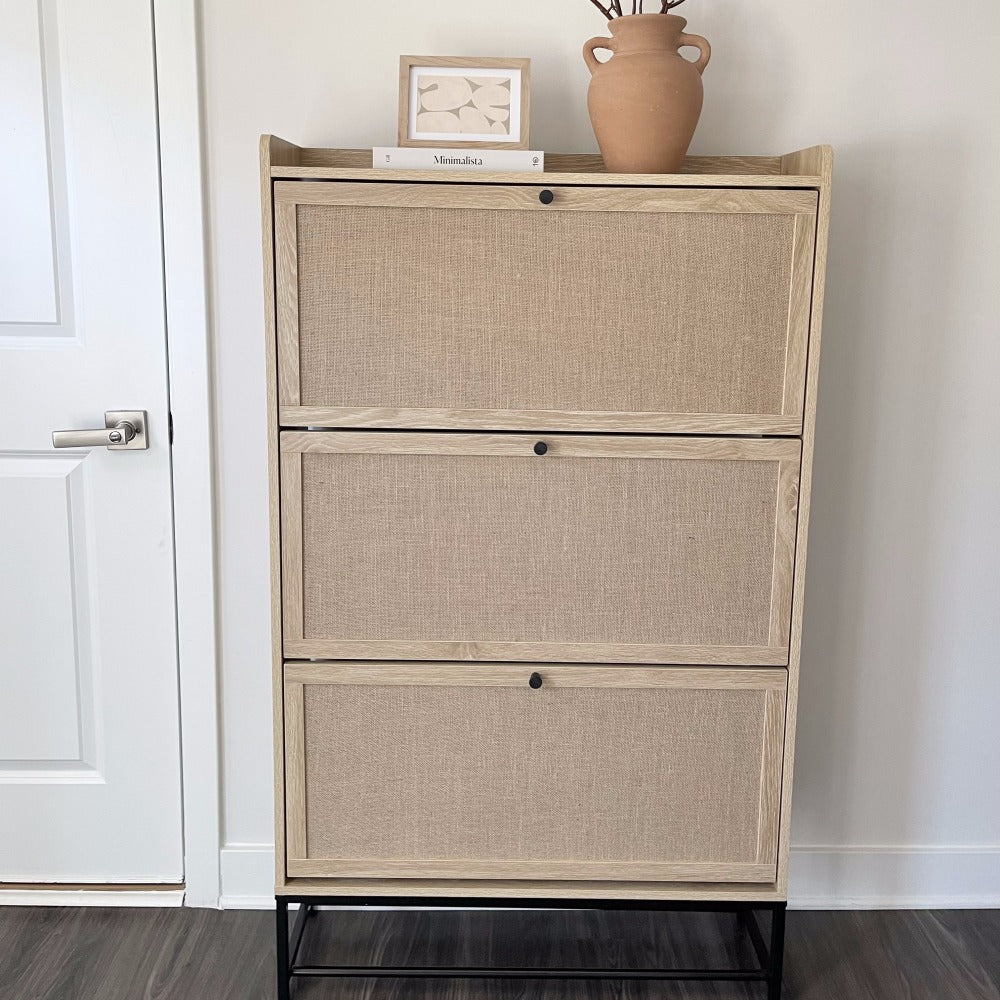 Shoe storage cabinet with wicker-like texture against a white wall.
