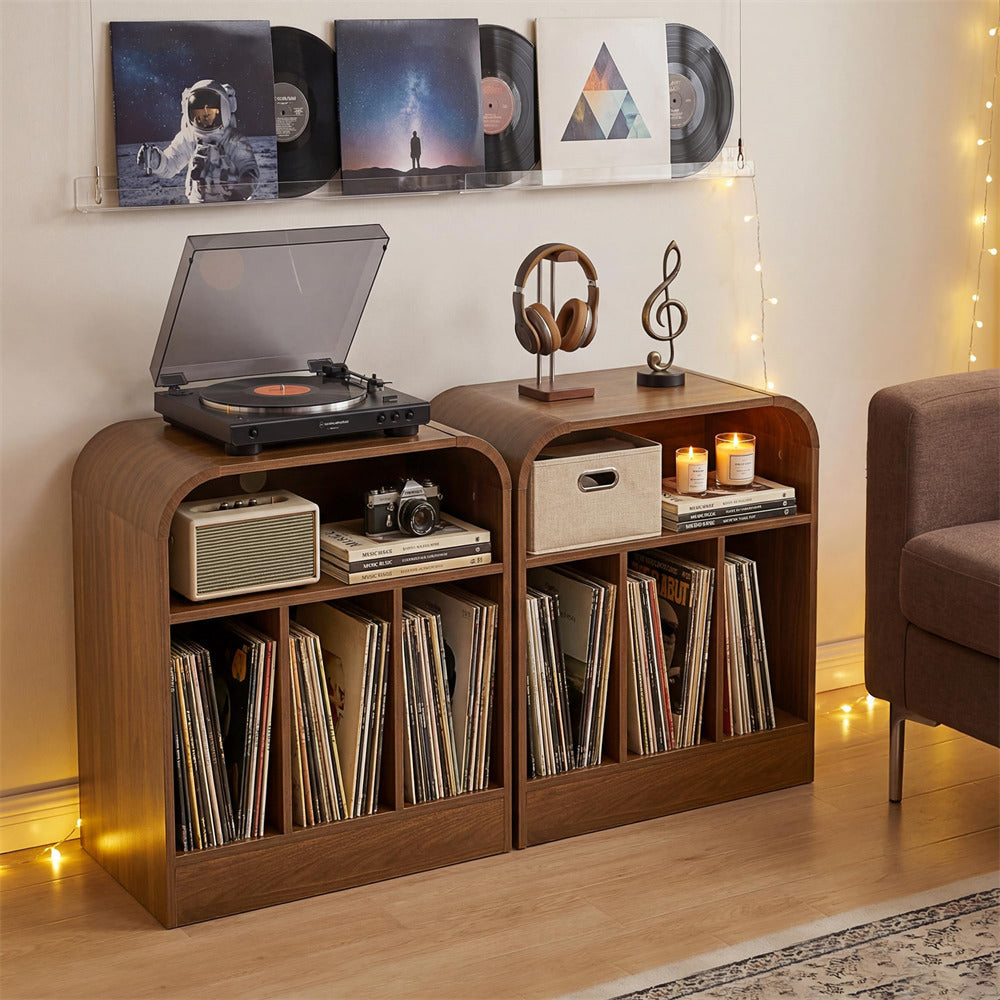 A pair of wooden record store display cabinets filled with vinyl records, styled in a cozy living room setting with a turntable, headphones, and warm string lights.