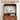 A wooden appliance cabinet with a tall back panel, shown with a white espresso machine on the lower shelf and hanging mugs on the back rail. Text at the top reads '27.
