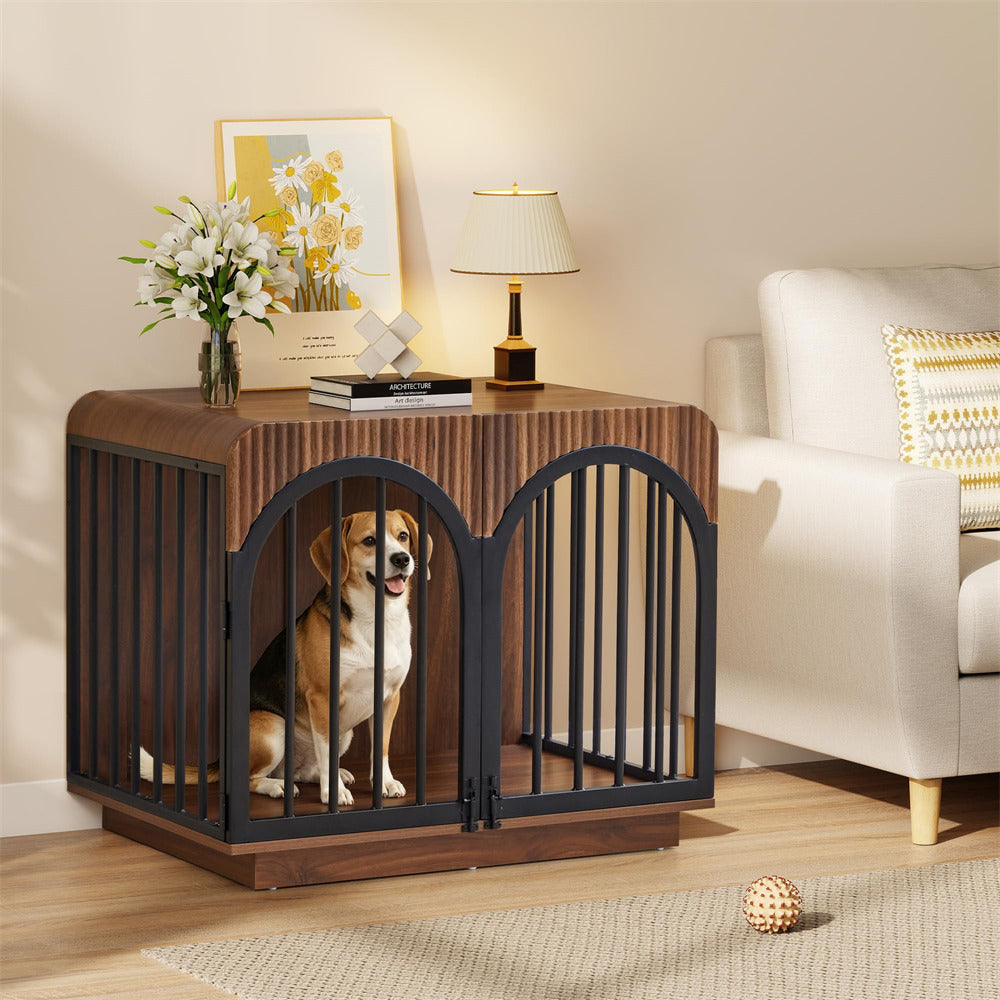 A wooden and black metal pet crate with arched doors sits in a living room setting next to a white armchair, with a dog sitting inside.