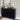 Black sideboard with decorative items against a gray wall