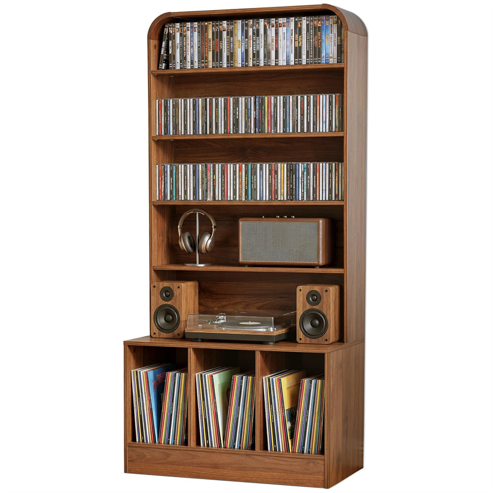 A tall wooden media console and shelf unit with multiple tiers, shown filled with DVDs, records, vinyl records, speakers, a turntable, and a small radio against a plain white background.