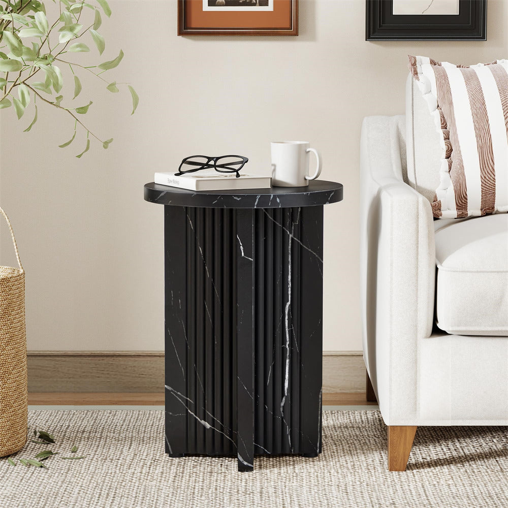 Black marble side table in a living room setting with a couch and decor items.