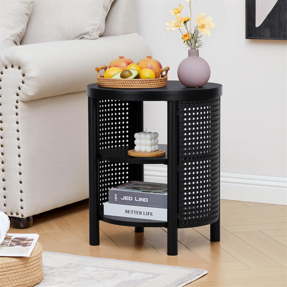 Black woven side table with books, fruit basket, and vase in a living room setting.