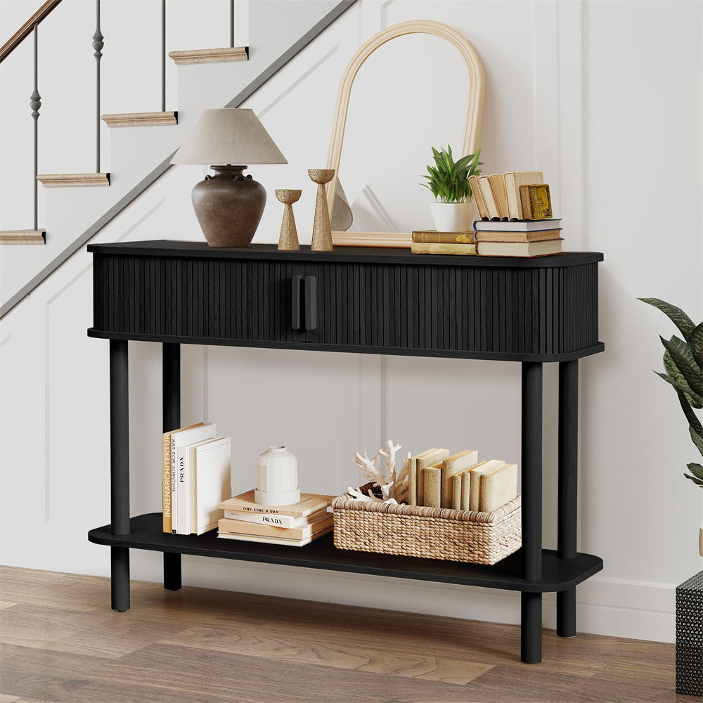 Black console table with decorative items in a room with a staircase.