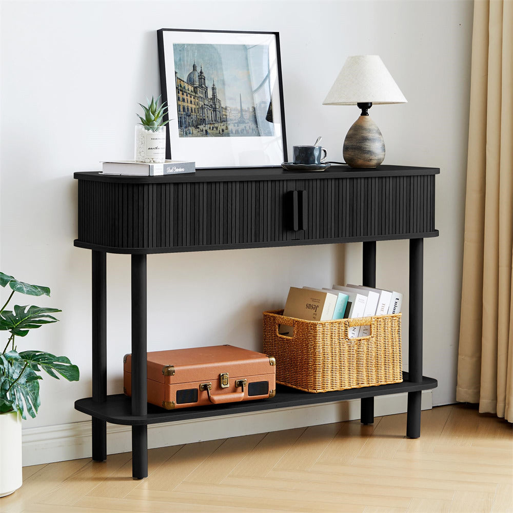 Black console table with a suitcase, basket, and decor items in a room setting.