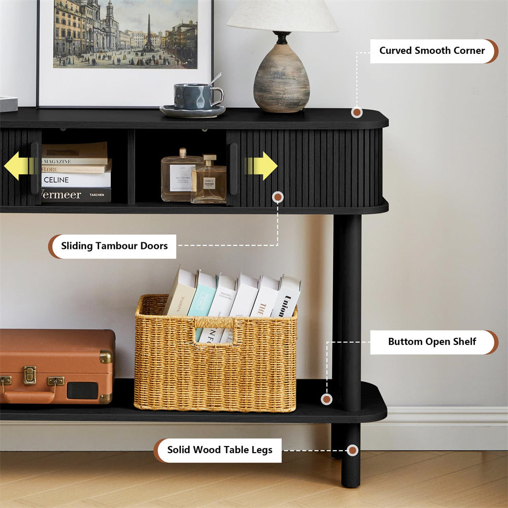 Black console table with sliding tambour doors, bottom open shelf, and solid wood legs, featuring a basket and books on a neutral background.
