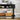 Black console table with sliding tambour doors, bottom open shelf, and solid wood legs, featuring a basket and books on a neutral background.