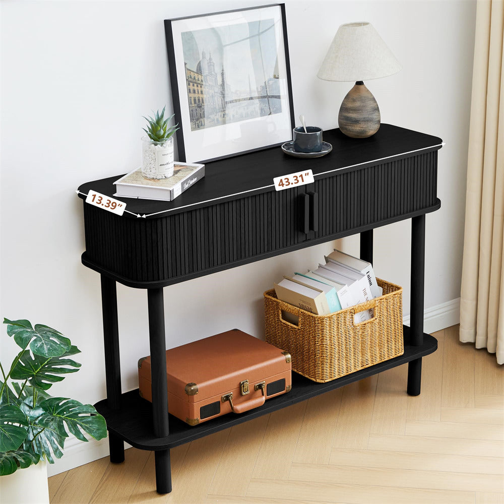 Black console table with a brown suitcase and wicker basket in a room setting.