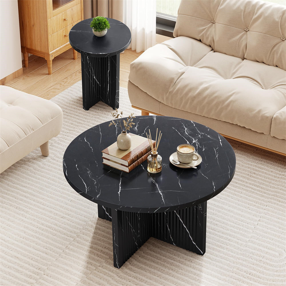 Black marble coffee table in a living room setting with decor items on top.