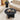Black marble coffee table in a living room setting with decor items on top.
