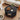 Round black coffee table with decorative items in a living room setting