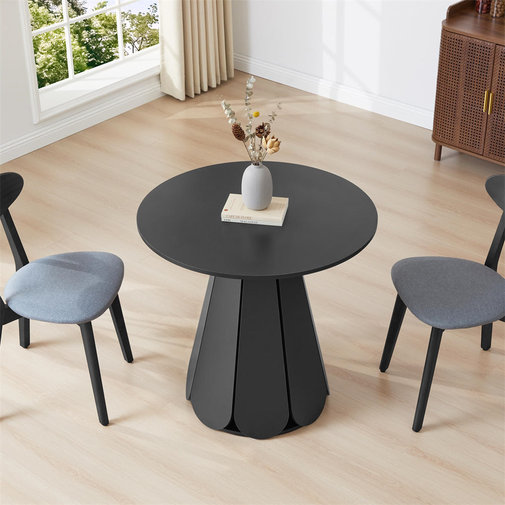 Black round table with decorative items in a room with chairs and a window.