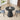 Black round table with decorative items in a room with chairs and a window.