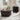 Round black coffee table with decorative items in a living room setting.