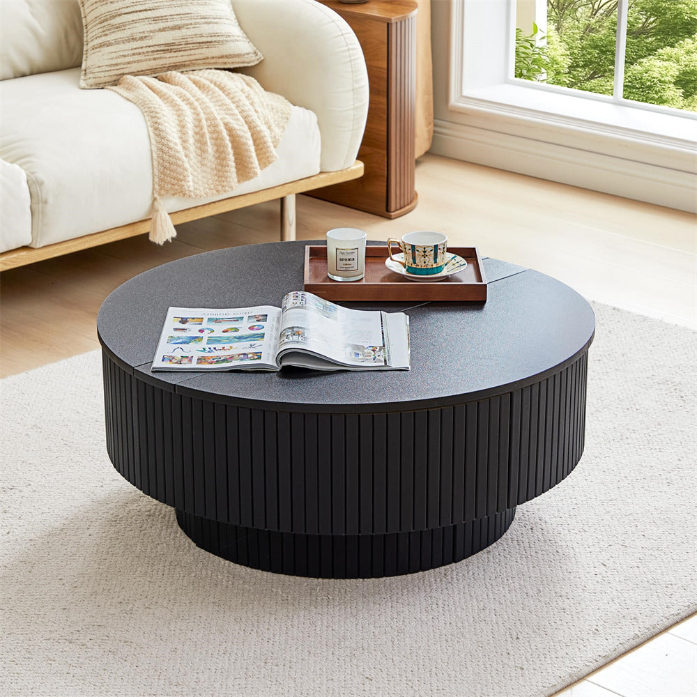 Round black coffee table in a living room with a newspaper, mug, and tray on top.