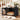 A black metal dog crate with an open door and mesh sides, shown in a staged home interior with a sleeping Shiba Inu dog inside on a cushioned bed. The crate is placed on a rug near toys, with a staircase and framed art in the background.