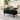 Black coffee table with a laptop, snacks, and a plant in a living room setting.