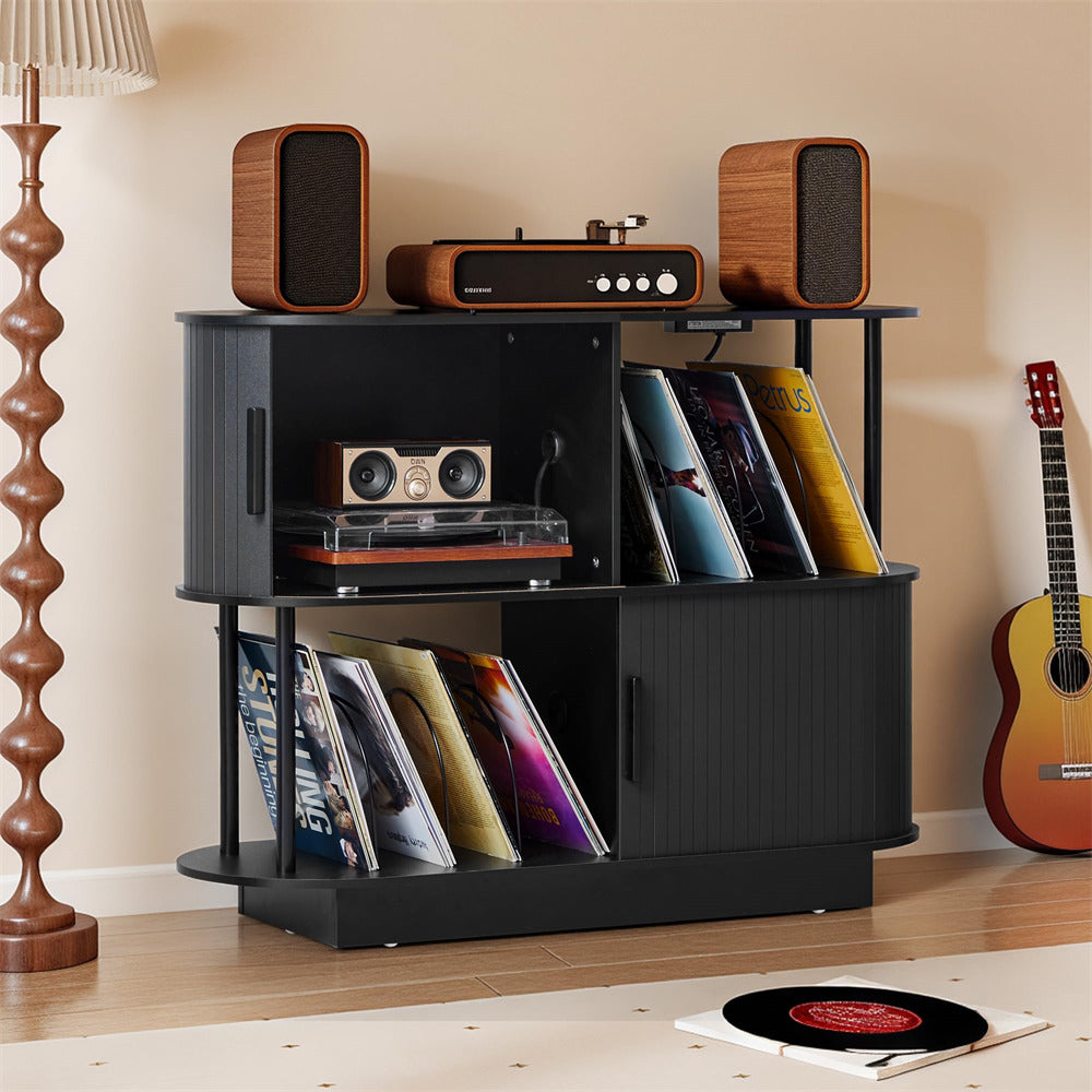 Black entertainment console with record players, speakers, and records on a wooden floor.