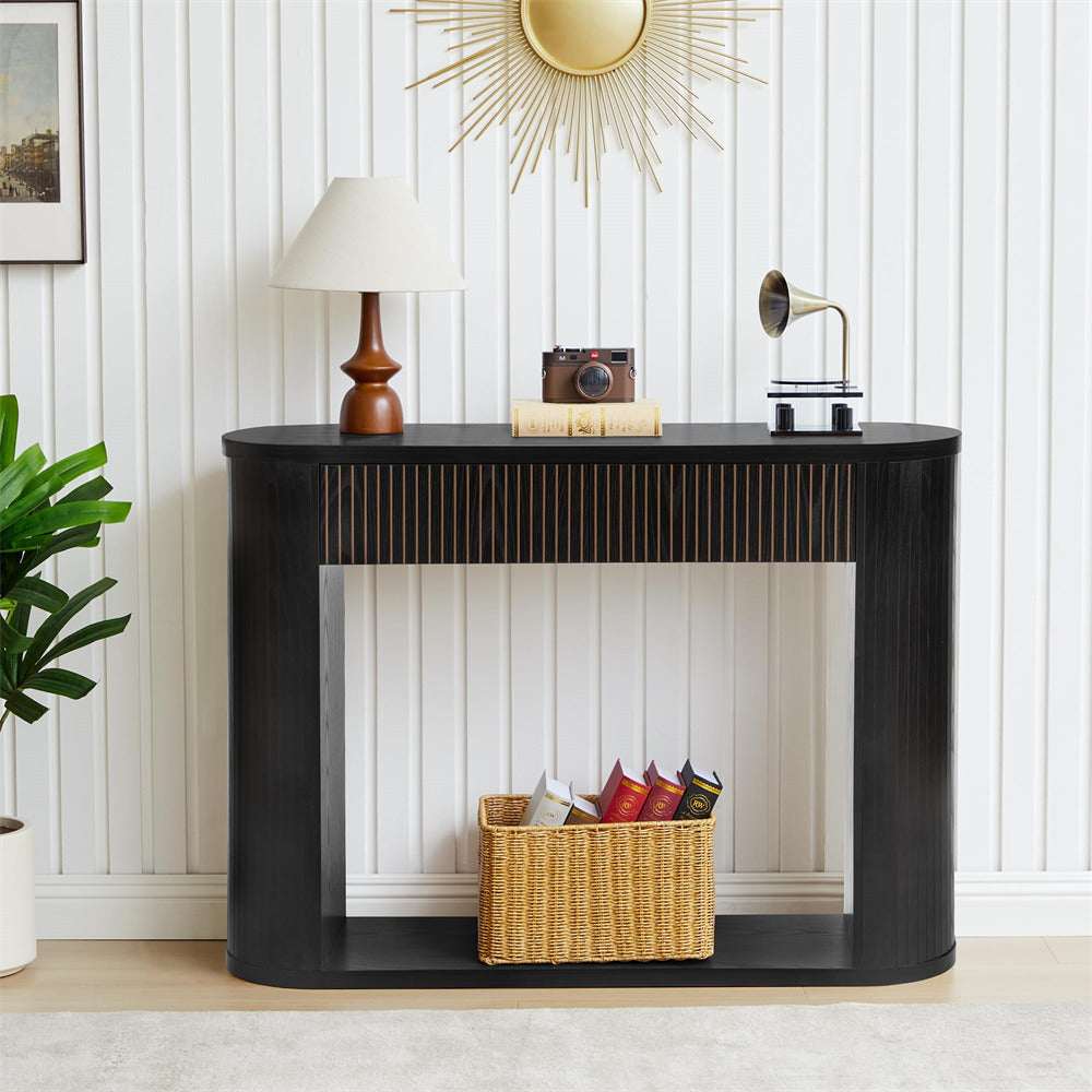 Black console table with decorative items against a white paneled wall.