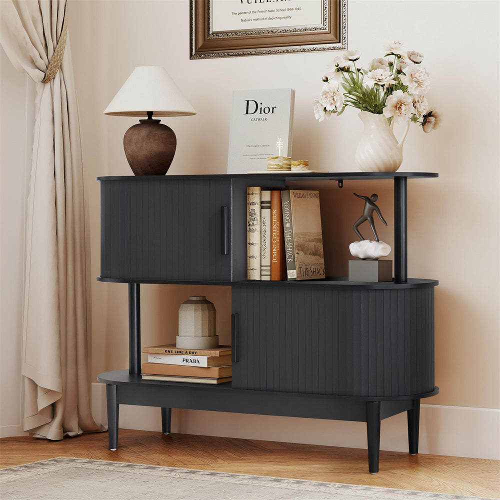 Black side table with books, a lamp, and decorative items in a room setting.