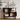 Black corner shelf with books, decorative items, and a framed picture in a room.
