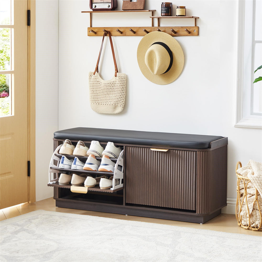 Shoe storage bench with open compartment showing shoes, closed compartment, and hat and bag on wall above.