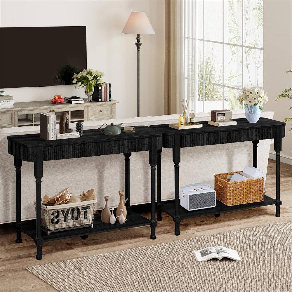 Two black console tables in a living room setting with decor items.