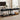 Two black console tables in a living room setting with decor items.