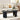 Black coffee table with a laptop, cup, and flowers in a living room setting.