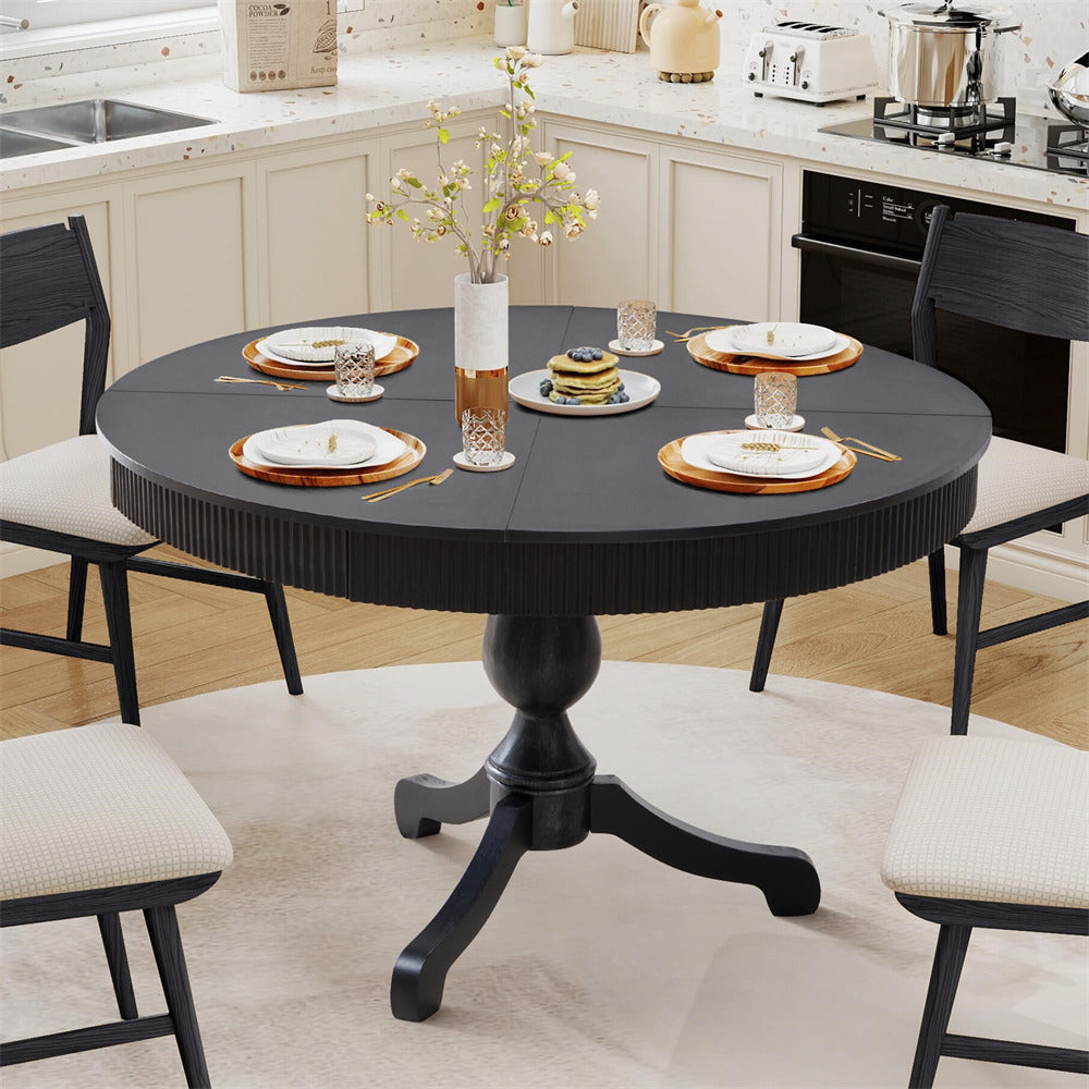 Round black dining table set with chairs in a kitchen