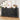 Black woven sideboard with decorative items in a room with wooden flooring and white walls.